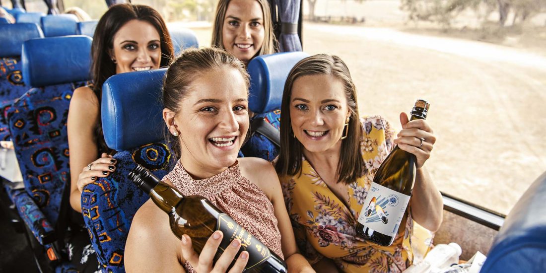 girls on wine tour bus holding wine